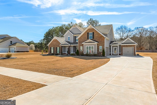 craftsman-style home with a garage, concrete driveway, a front lawn, board and batten siding, and brick siding