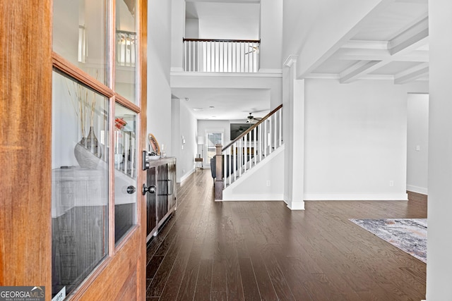 foyer entrance featuring hardwood / wood-style floors, stairway, beam ceiling, and baseboards