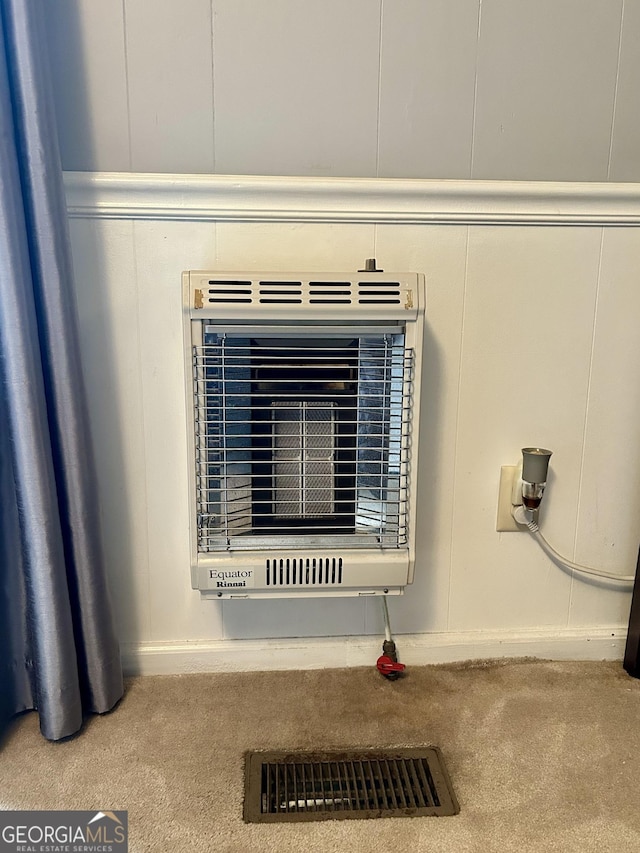 interior details with a decorative wall, carpet, and heating unit