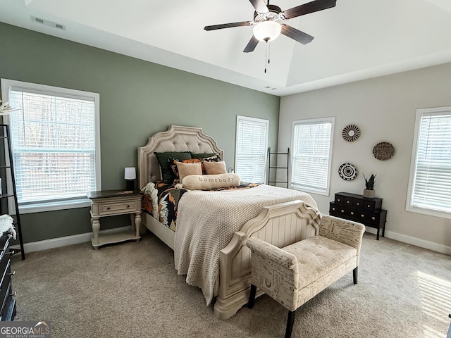 bedroom featuring light carpet, multiple windows, visible vents, and baseboards