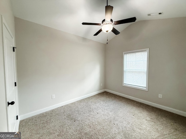 unfurnished room featuring carpet flooring, a ceiling fan, visible vents, vaulted ceiling, and baseboards