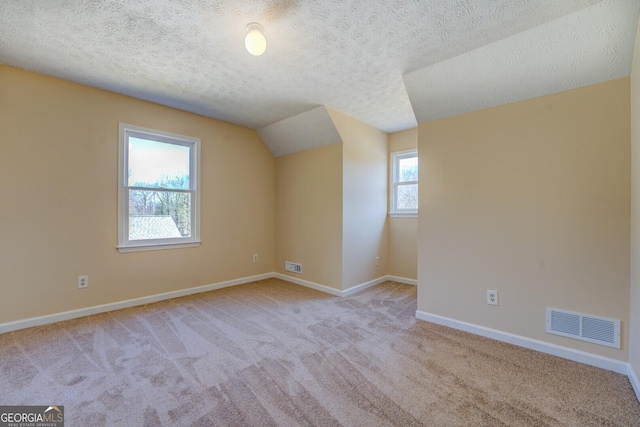 bonus room with carpet floors, visible vents, vaulted ceiling, and baseboards