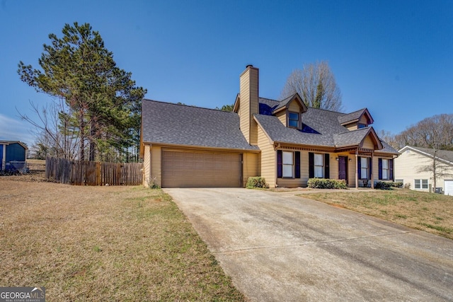 view of front of home featuring roof with shingles, an attached garage, a front yard, fence, and driveway