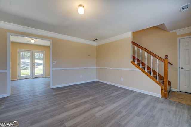 unfurnished living room with stairs, visible vents, wood finished floors, and ornamental molding