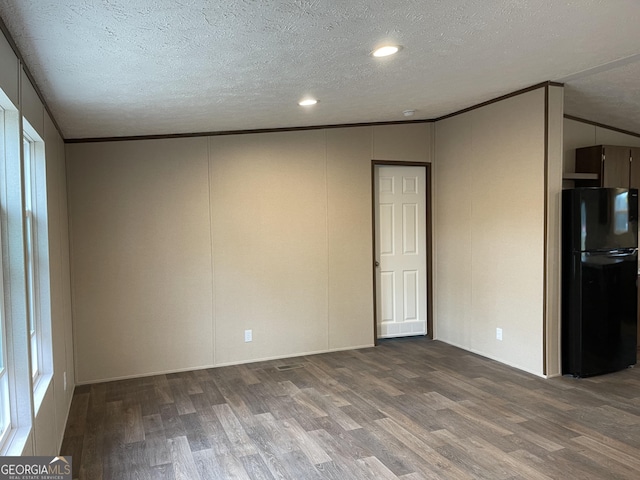 empty room featuring crown molding, a textured ceiling, and wood finished floors