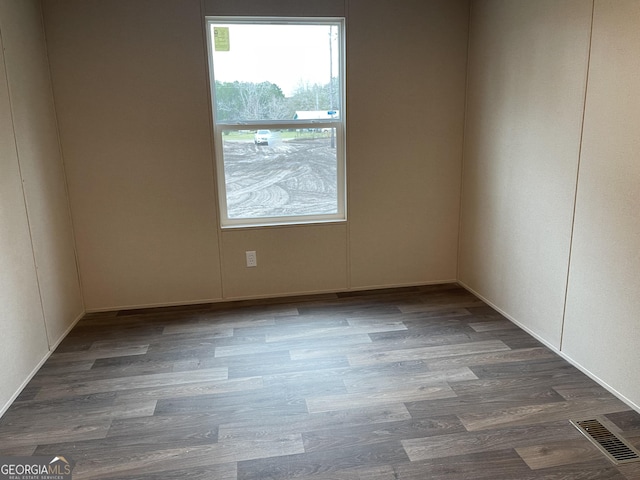 empty room with wood finished floors and visible vents