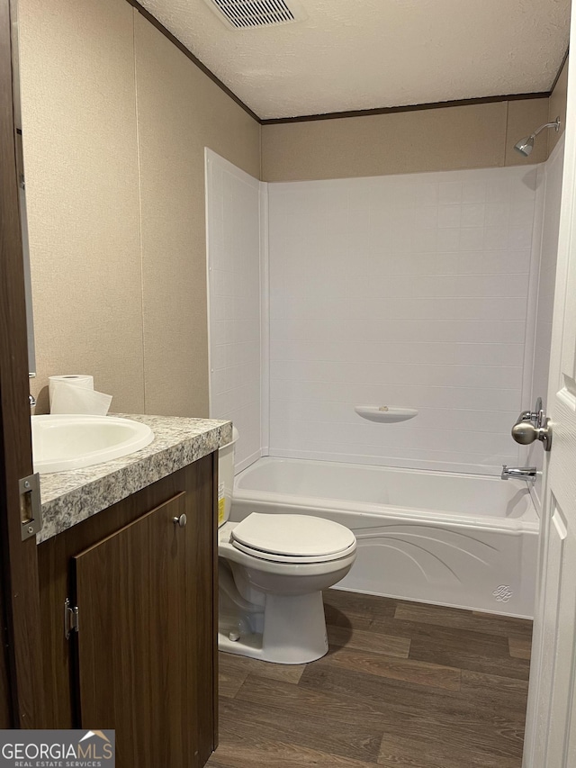 bathroom featuring vanity, shower / bathing tub combination, wood finished floors, and toilet