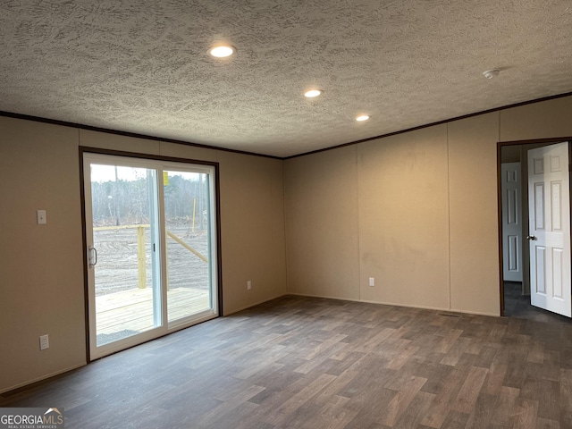 unfurnished room featuring a textured ceiling, ornamental molding, and wood finished floors