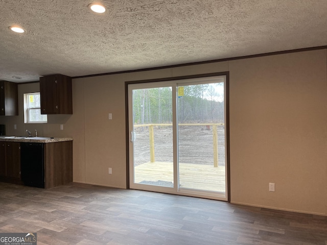 kitchen with a textured ceiling, dark brown cabinetry, black dishwasher, light countertops, and light wood-type flooring