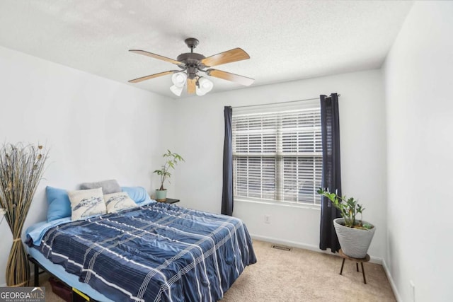 bedroom featuring visible vents, a ceiling fan, carpet flooring, a textured ceiling, and baseboards