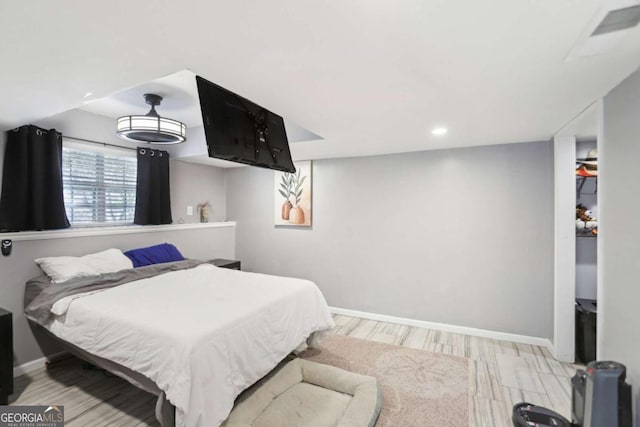 bedroom with visible vents, baseboards, and wood finished floors