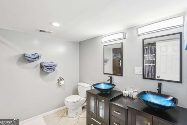 full bathroom featuring toilet, tile patterned flooring, visible vents, and a sink