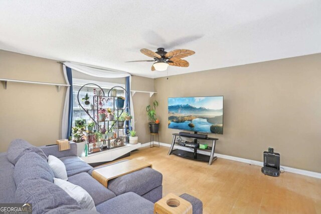 living area with ceiling fan, baseboards, and wood finished floors