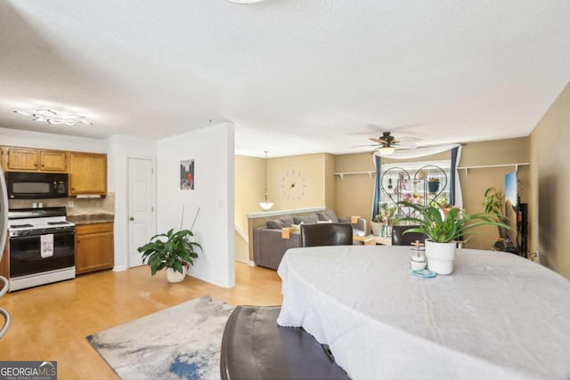 dining space featuring a ceiling fan and light wood-style flooring
