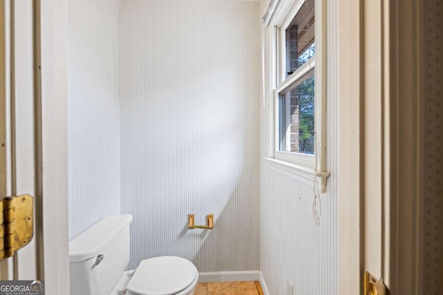 bathroom featuring toilet, wallpapered walls, tile patterned flooring, and baseboards