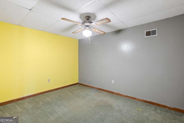 spare room featuring baseboards, visible vents, ceiling fan, carpet flooring, and a paneled ceiling