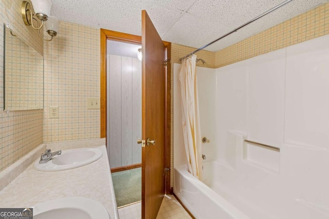 bathroom featuring tile patterned floors, double vanity, a sink, and shower / bath combo with shower curtain