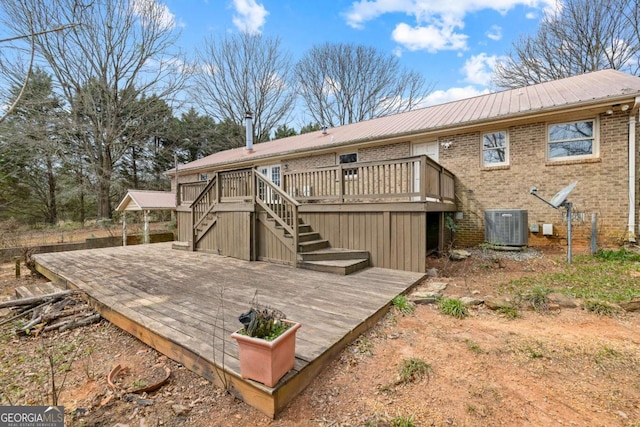 back of house with metal roof, central AC unit, brick siding, stairway, and a wooden deck