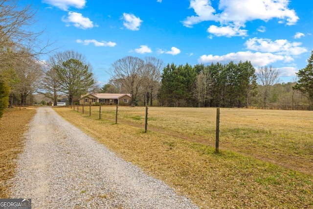 view of street with driveway and a rural view