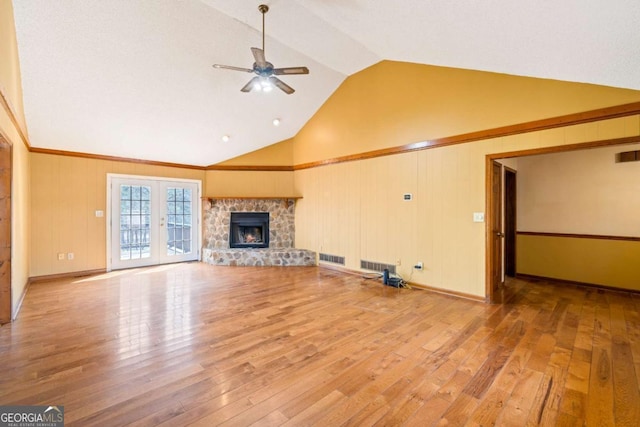 unfurnished living room featuring french doors, a fireplace, visible vents, a ceiling fan, and hardwood / wood-style floors