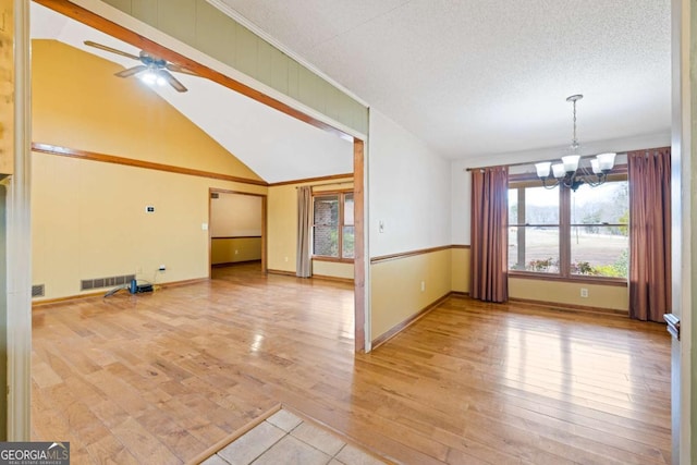 unfurnished living room featuring crown molding, light wood finished floors, vaulted ceiling, a textured ceiling, and ceiling fan with notable chandelier