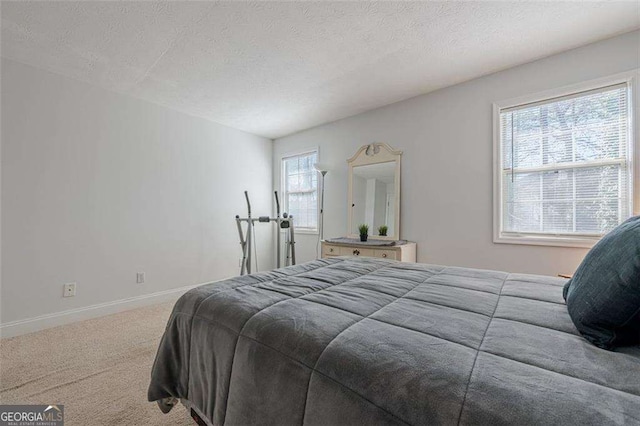 carpeted bedroom featuring a textured ceiling and baseboards