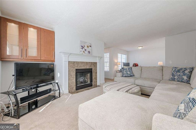 living room with a textured ceiling, carpet floors, and a tile fireplace