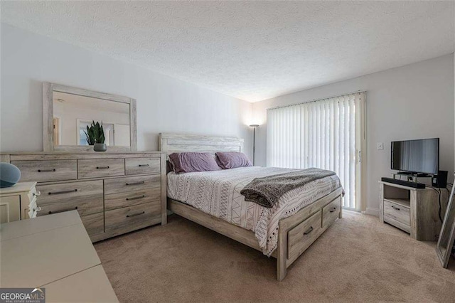 bedroom featuring light carpet and a textured ceiling