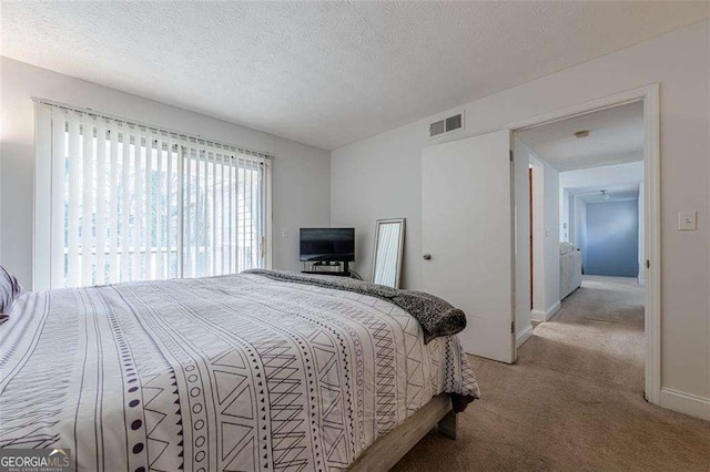 bedroom with baseboards, carpet flooring, visible vents, and a textured ceiling