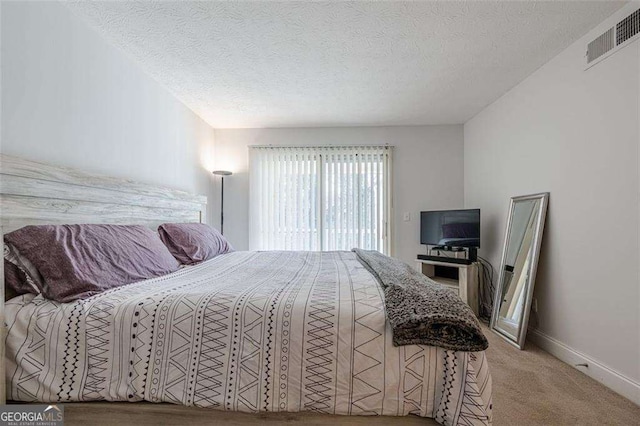 carpeted bedroom with visible vents, a textured ceiling, and baseboards