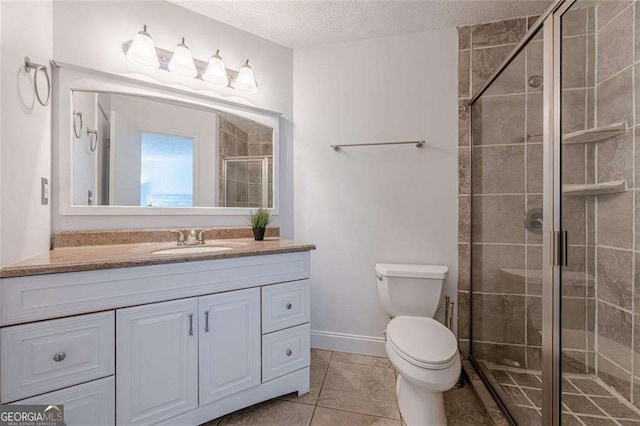 bathroom with a stall shower, toilet, tile patterned floors, a textured ceiling, and vanity