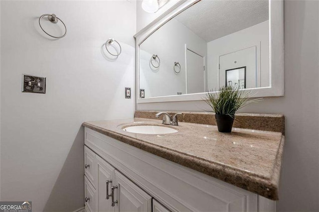 bathroom featuring a textured ceiling and vanity