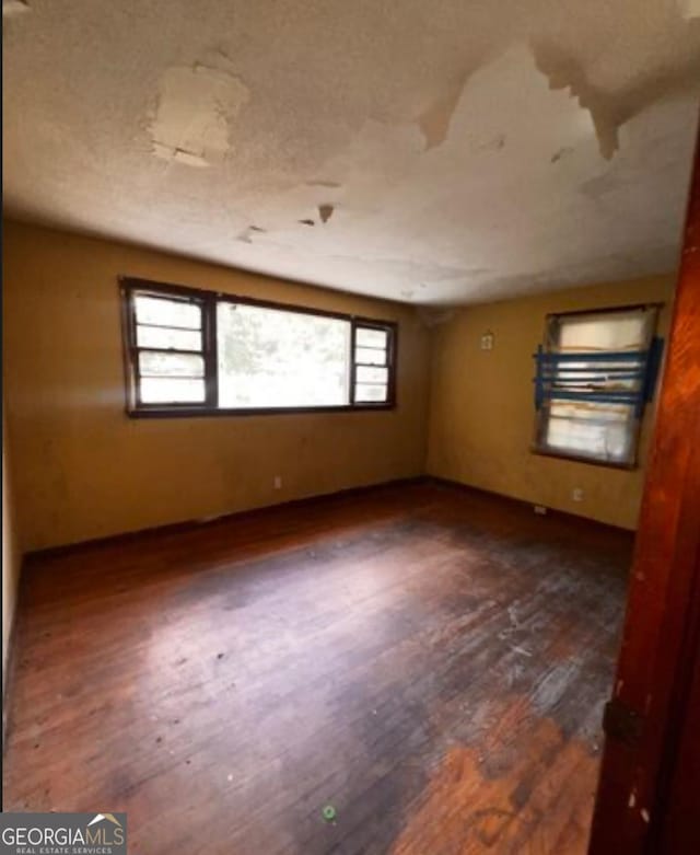 1188 Sunnydale Dr, Macon, GA 31217 - spare room featuring dark wood-style floors, baseboards, and a textured ceiling