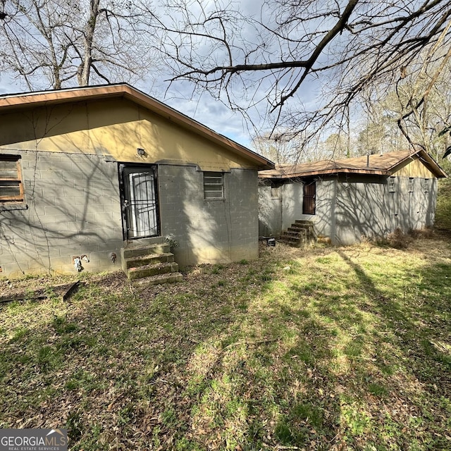 1188 Sunnydale Dr, Macon, GA 31217 - view of side of home featuring entry steps, concrete block siding, and a lawn