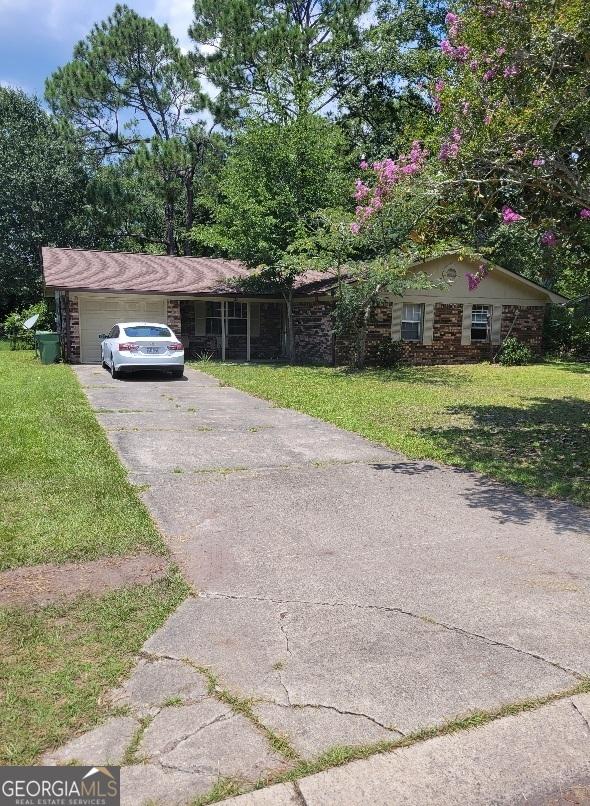 view of front of home with a front yard, driveway, and an attached garage