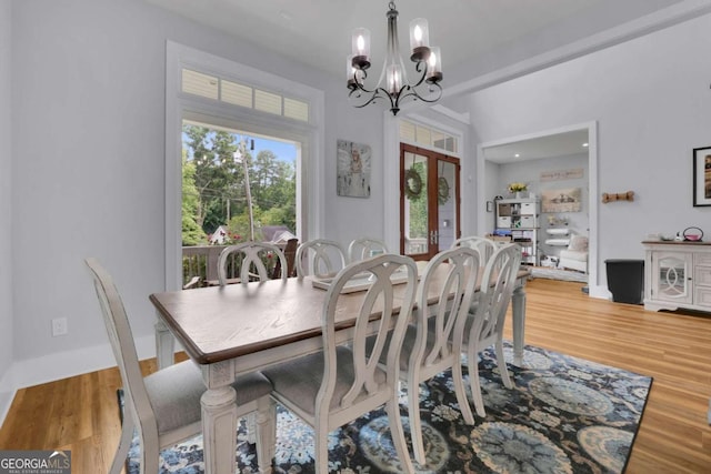 dining room featuring a chandelier, wood finished floors, and french doors