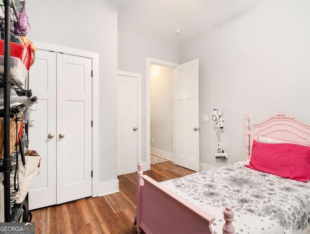 bedroom featuring a closet, baseboards, and wood finished floors