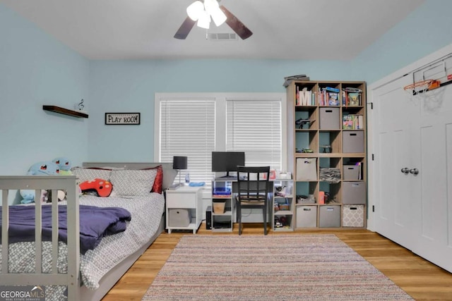 bedroom featuring ceiling fan, wood finished floors, and visible vents