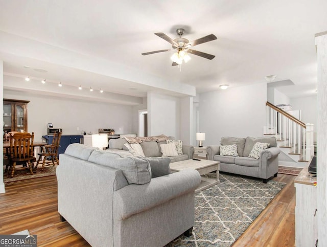 living room featuring stairs, ceiling fan, and wood finished floors