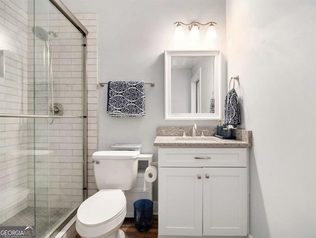 bathroom featuring a stall shower, vanity, and toilet