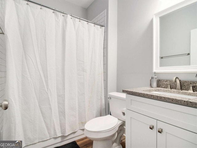 bathroom with toilet, wood finished floors, and vanity