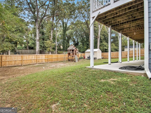 view of yard featuring a storage shed, a fenced backyard, an outdoor structure, and a patio