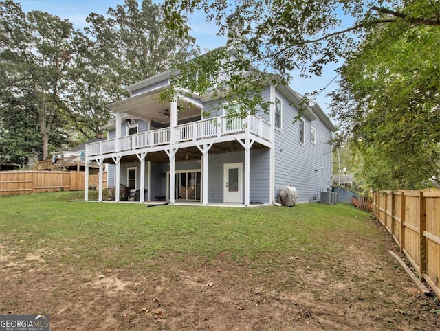 back of property featuring a yard, a fenced backyard, a ceiling fan, and central air condition unit