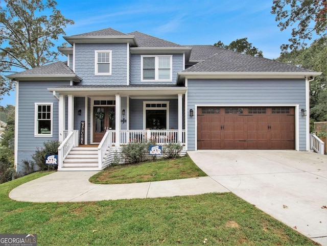 view of front of house with roof with shingles, covered porch, an attached garage, driveway, and a front lawn