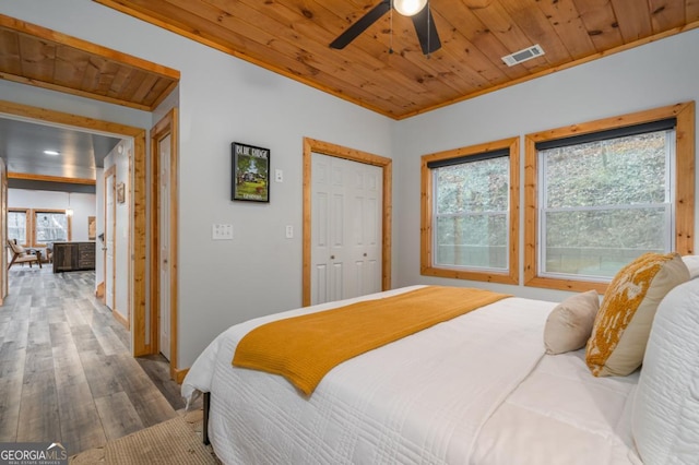 bedroom featuring a closet, visible vents, ceiling fan, wooden ceiling, and hardwood / wood-style flooring