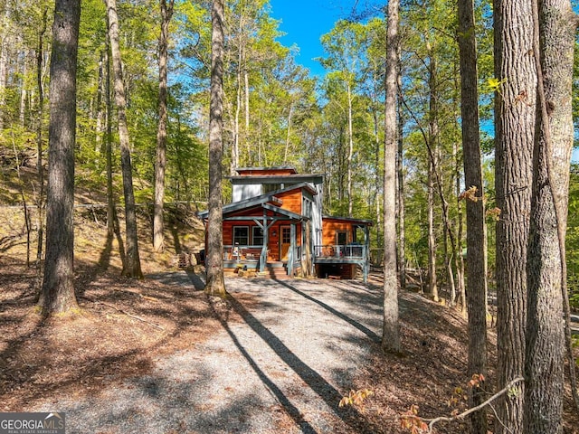 view of outdoor structure featuring covered porch and a forest view