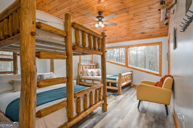 bedroom with vaulted ceiling, wood finished floors, wood ceiling, and baseboards