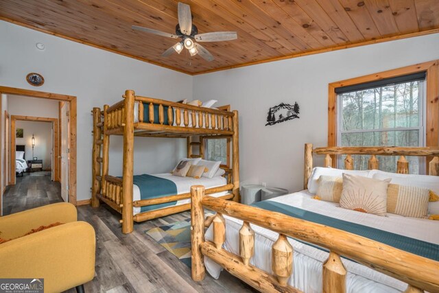 bedroom with wooden ceiling, crown molding, and wood finished floors