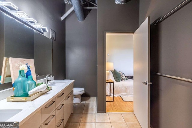 full bath featuring tile patterned flooring, a sink, toilet, and double vanity