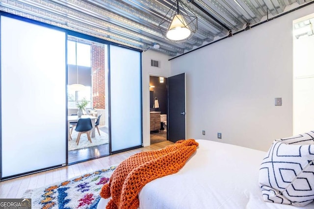 bedroom featuring visible vents and wood finished floors